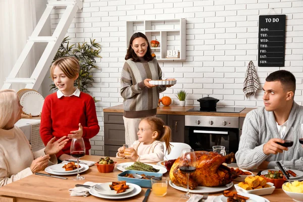 Şükran Günü 'nde mutlu bir aile şenlik masasında yemek yiyor.