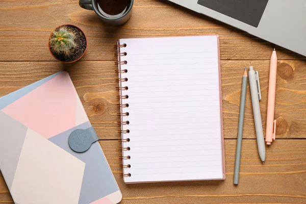 Kalemli defterler ve ahşap arka planda bir fincan lezzetli kahve.