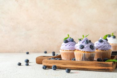 Beyaz arka planda yabanmersinli ve naneli lezzetli keklerden oluşan ahşap tahta bir tahta.