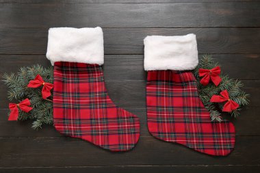 Noel çorapları köknar dalları ve tahta arka planda fiyonklar