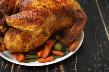 Lezzetli kızarmış hindi tabağı ve siyah ahşap arka planda Şükran Günü için farklı sebzeler.