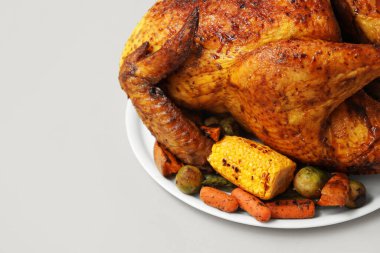 Beyaz arka planda, Şükran Günü için lezzetli kızarmış hindi ve farklı sebzeli tabak.