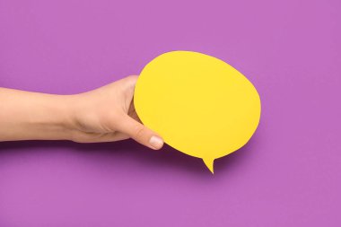 Mor arka planda boş konuşma balonu tutan kadın