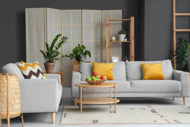 Masada elmalar ve kanepeler olan modern oturma odasının içinde.