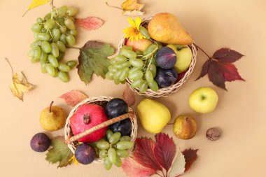 Bej arka planda farklı taze meyveler olan sepetler.