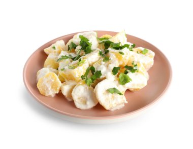 Beyaz arka planda yeşil salatalı lezzetli patates salatası.