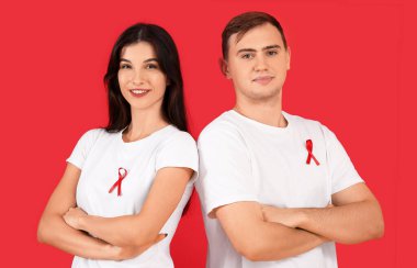 Arka planda kırmızı kurdeleli genç bir adam ve kadın. Dünya AIDS Günü konsepti