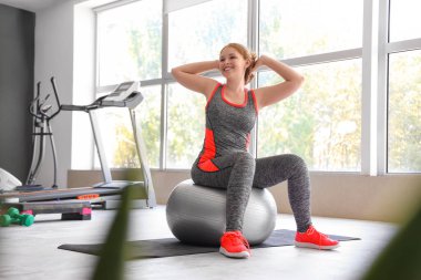 Spor giyimli güzel bir kadın spor salonunda spor salonunda spor salonunda spor yapıyor.