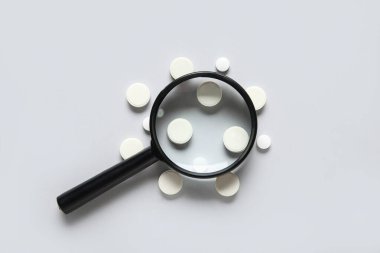 Gri arkaplanda haplar olan büyüteç