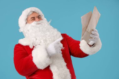 Noel Baba mavi arka plandaki harflere bakıyor.