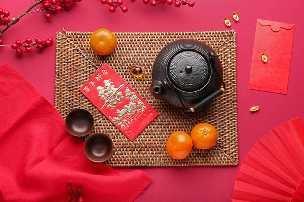 Teapot with mandarins, envelopes and oriental symbols on red background. New Year celebration