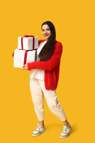 Mooie Jonge Vrouw Met Kerstcadeaus Gele Achtergrond — Stockfoto