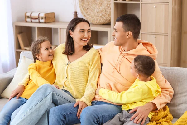 Mutlu bir aile evdeki kanepede oturuyor.