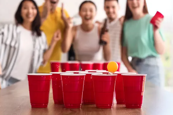 Cups for beer pong on table at party, closeup