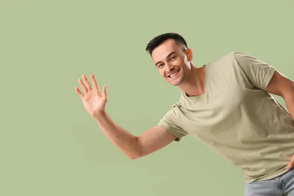 Schöner Mann Winkt Mit Der Hand Auf Grünem Hintergrund — Stockfoto
