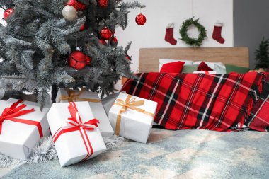 Noel ağacının altındaki hediye kutuları şenlikli yatak odasında, yakın plan.