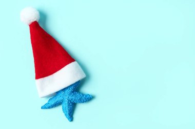Mavi arka planda Noel Baba şapkalı denizyıldızı