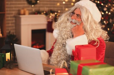 Noel arifesinde evde dizüstü bilgisayarlı Noel Baba