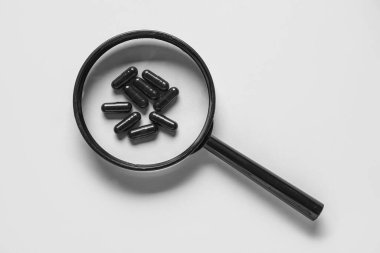 Gri arkaplanda haplar olan büyüteç