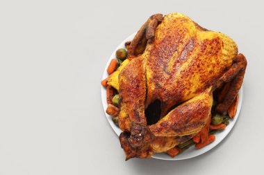 Beyaz arka planda, Şükran Günü için lezzetli kızarmış hindi ve farklı sebzeli tabak.