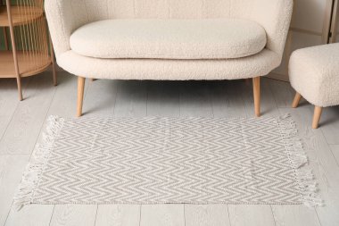 Şık halısı, beyaz kanepesi ve puf olan oturma odasının içinde.