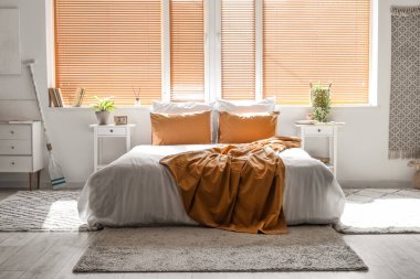 Büyük yataklı, masalı ve pencereli aydınlık yatak odasının içi