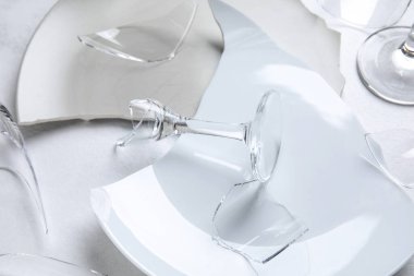 Kırık bardakların ve arka plandaki tabakların yakın görüntüsü