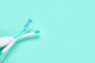 Arkaplanda elektrik ve plastik diş fırçaları.