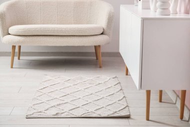 Şık halısı, kanepesi ve beyaz büfesi olan oturma odasının içinde.