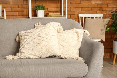 Modern oturma odasının içinde yastıkları olan rahat gri kanepe, yakın plan.