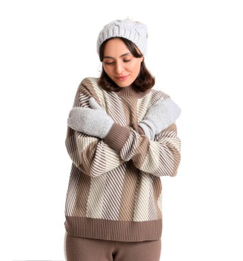 Beyaz arka planda kalın kazaklı genç bir kadın.