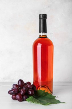 Beyaz duvarın yanında üzümlü bir şişe nefis şarap.