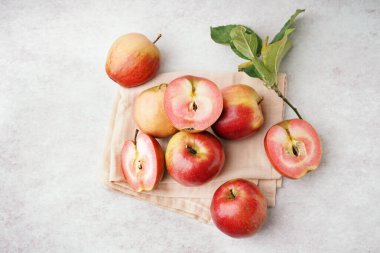 Tatlı pembe elmalar ve beyaz arka planda yapraklar