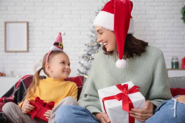 Küçük kızı ve evde Noel hediyeleriyle mutlu bir anne.
