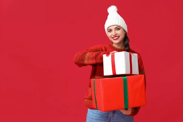 Mooie Jonge Vrouw Met Kerst Geschenken Rode Achtergrond — Stockfoto