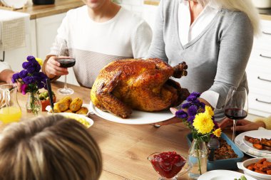 Şükran Günü 'nde şenlik masasında yemek yiyen mutlu aile, yakın çekim.