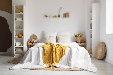 İçinde raf üniteleri ve balkabakları olan rahat bir yatak odası.