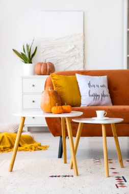 Oturma odasının içinde kırmızı kanepe ve masalar.