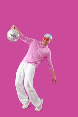 Havalı olgun bir adam, disko topuyla mor arka planda dans ediyor.