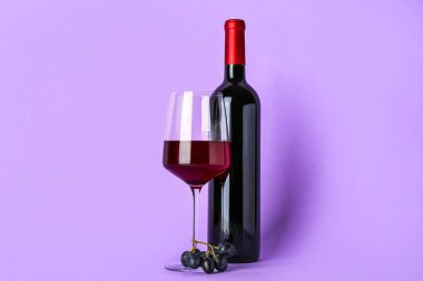 Eflatun arka planda cam ve bir şişe nefis şarap.