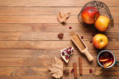 Portakallı sıcak şarap ve ahşap zemin üzerinde nar.