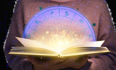 Woman reading astrology book on dark background, closeup clipart