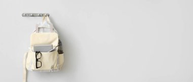 Okul çantası ışık duvarında asılı. Tasarım için pankart