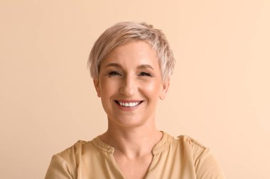 Mature blonde woman on beige background