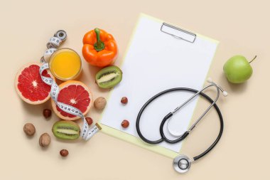 Pano, steteskop, mezura ve arkaplanda sağlıklı yiyecekler içeren kompozisyon