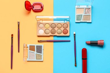 Güzel göz falı paletleri ve renkli arka planda farklı dekoratif kozmetikler.