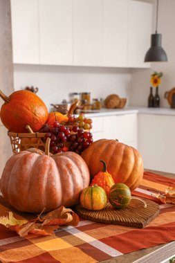 Modern mutfakta kabaklı, sonbahar yapraklı ve üzümlü bir masa.