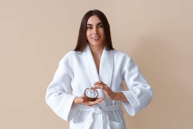 Bej arka planda hindistan cevizi yağı kabuğu olan güzel genç bir kadın.