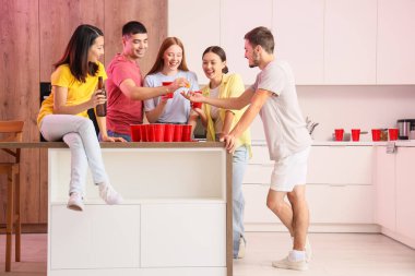 Bir grup genç arkadaş partide bira pong oynuyorlar.