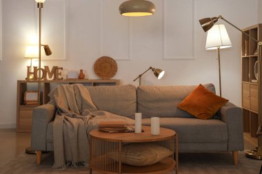 Kanepe, masa ve gece lambasıyla oturma odasının içinde.